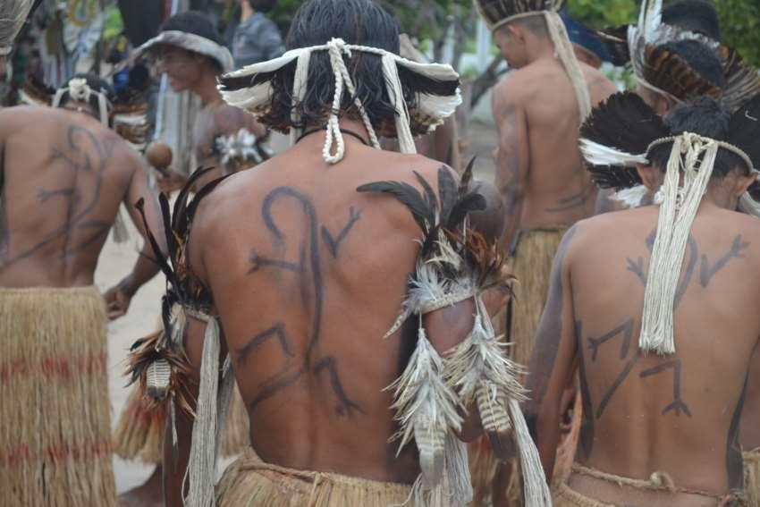 Jovem kalankó com pintura corporal de um calango,