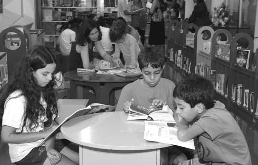 4 Crianças lendo na Biblioteca FNLIJ durante o Natal com Leituras.