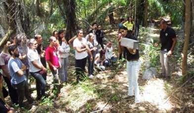 a b Figura 21 - (a) Palestra sobre mamíferos de importância médica e (b) Demonstração aos novos alunos sobre as técnicas de amostragem para captura de mamíferos.