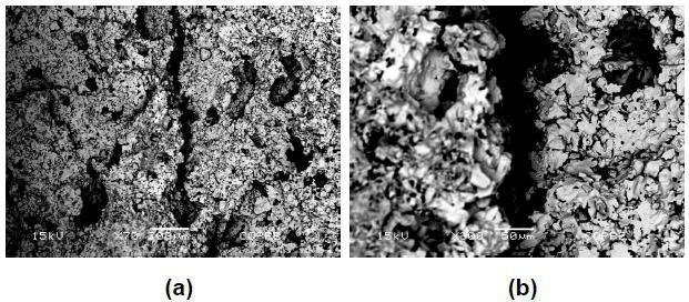 Figura III-26 Micrografias de microscopia eletrônica de varredura de uma pelota após o ensaio de tamboramento em corte com um aumento de 70 vezes (Figura a) e com um aumento de 300 vezes (Figura b)