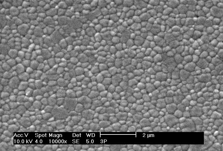 8 Figura 3: Micrografia, obtida por MEV, da superfície polida e atacada termicamente da amostra cerâmica 3Y-TZP, contendo pequena fração de fase monoclínica, observada nos grãos de maior tamanho onde