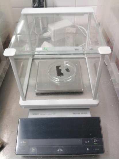 3. Materiais e descrição do ensaio experimental Figura 3.19 Balança de precisão 0,001g e tina de vidro usada na pesagem dos provetes Figura 3.
