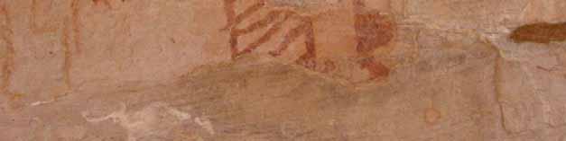 A cabeça está pintada com pintura uniforme e possui traços ornamentando-a, no topo. Um traço na parte lateral inferior sugere um falo voltado para o lado da figura que se apresenta de perfil.