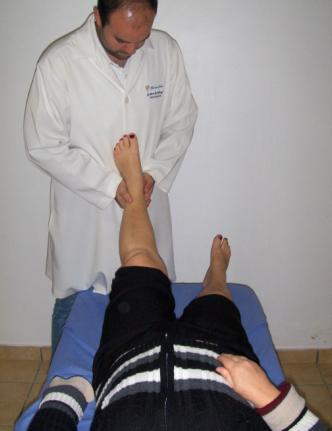 Osteopata do lado do membro inferior a ser manipulado, toma contato com a mão inferior sob o dorso do pé do paciente e com a mão superior