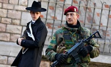 We now have a heavily armed soldier on the gate : a Belgian paratrooper keeps guard outside a Jewish school in Antwerp.