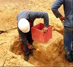 a) Escavar o solo com uso lâmina, moldando um cubo de 30x30x30cm³ (Figura a e Figura b); b) Envolver as faces expostas do bloco com 3 camadas de tecido (talagarça) e parafina