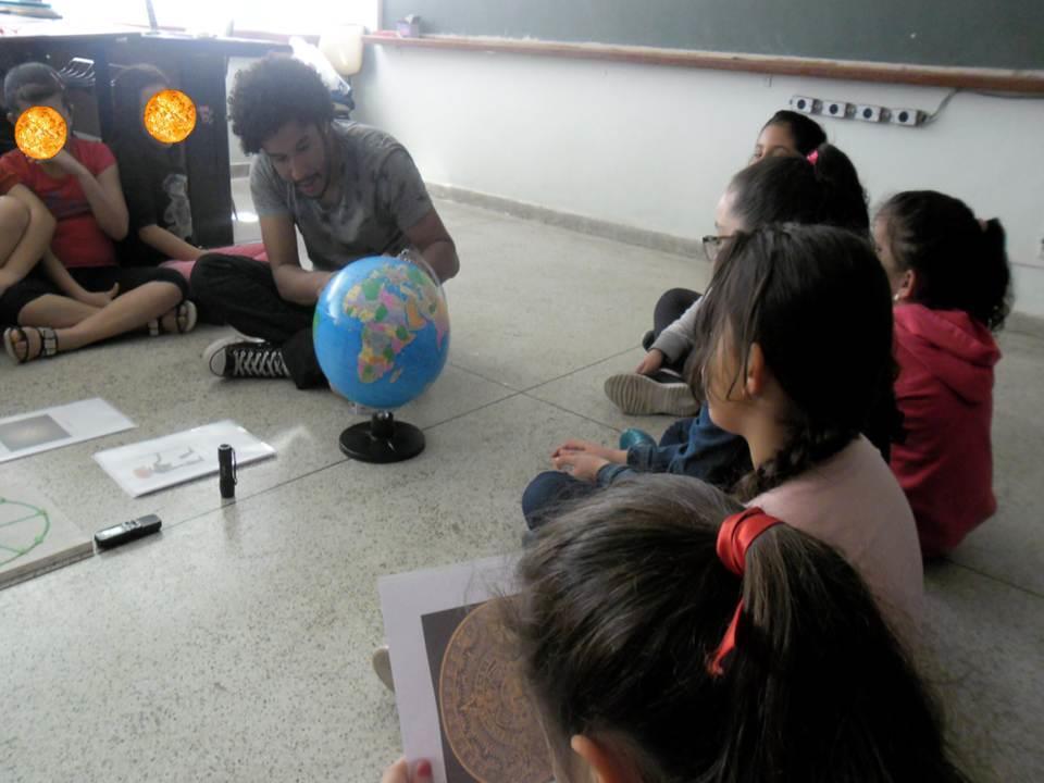 Figura 4 - Usando o globo para localizar as diferentes regiões onde habitavam os povos discutidos na aula A etapa final do encontro foi a apresentação de 3