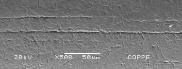 A análise em MEV do fio mostra ausência de rugosidade em sua superfície, porém marcas e ranhuras são observadas,