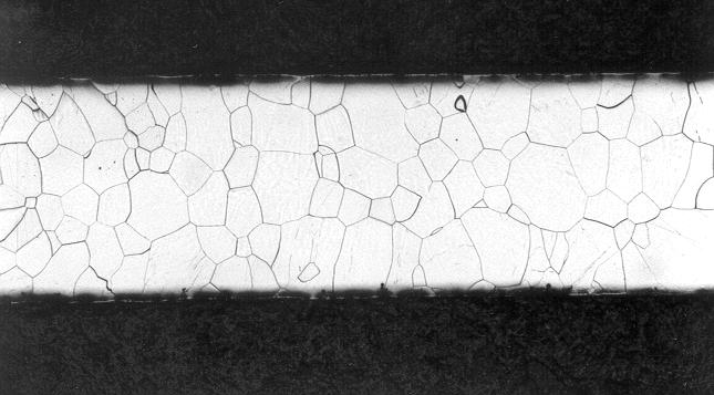 Figura 3. Seção longitudinal de tira de aço silício produzida por LCT no MPI-E. Espessura da tira: 2,1mm. Nota-se grãos colunares na superfície superior da tira. Figura 4.