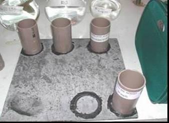 um destes corpos-de-prova foram colados pequenos tubos de PVC (φ =55mm), que depois de 24 h foram preenchidos com os reagentes químicos, cujas concentrações e tempos de exposição encontram-se