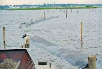 O encapsulamento da areia dragada em formas geossintéticas evita a erosão por ondas e vento, acelerando assim o cronograma das obras. Holanda, 2012.