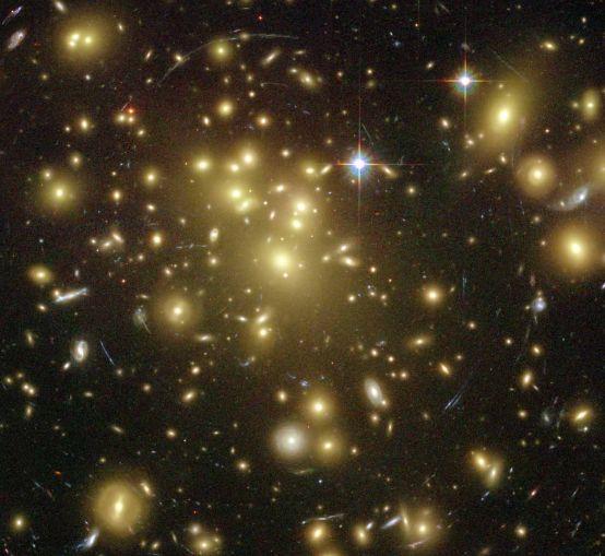 INTRODUÇÃO Arcos gravitacionais são imagens altamente distorcidas e magnificadas de galáxias distantes (denominadas fontes) devido à deflexão da luz pelo campo gravitacional de galáxias ou
