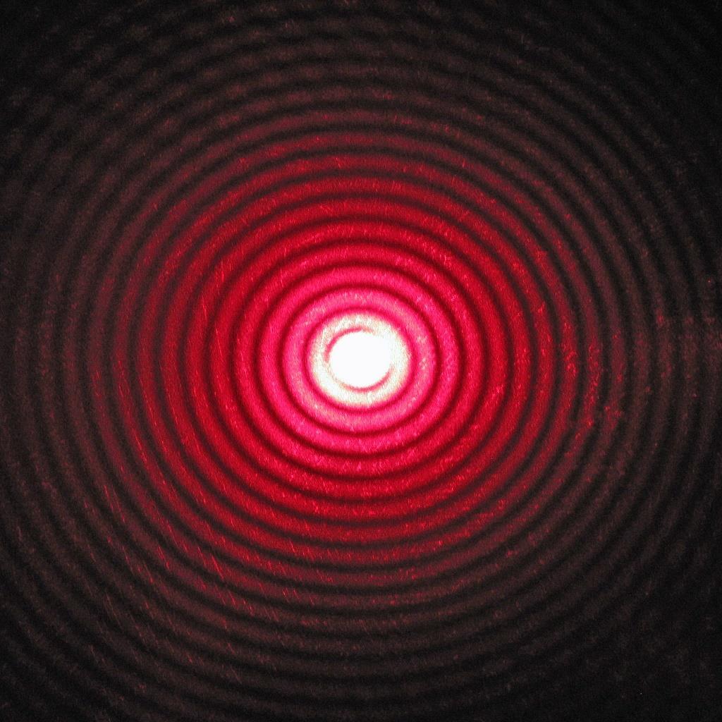 O Ponto Claro de Fresnel Fotografia da figura de difração produzida por um disco. Observe os anéis de difração concêntricos e o ponto claro de Fresnel no centro.