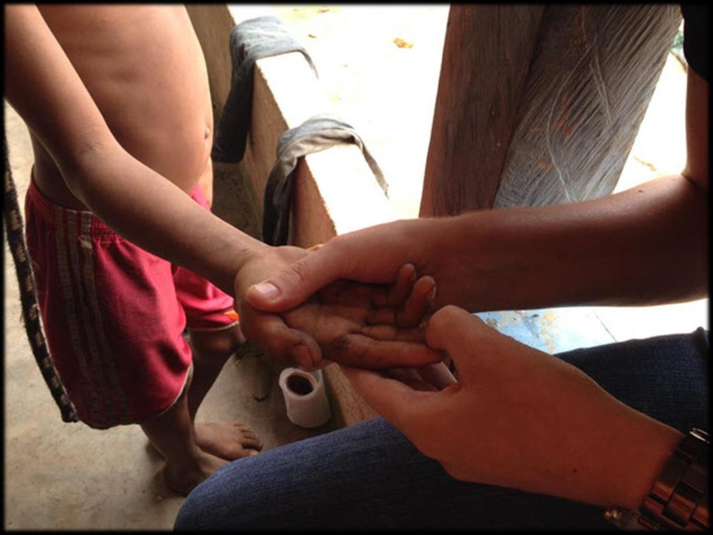 O papel da Inspeção do Trabalho Legenda - Auditora-Fiscal do Trabalho examinando a mão de uma criança indígena da etnia Yanomami em Mucajaí/RR.