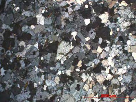 Podem ainda ocorrer grãos em torno de 0,1mm inclusos nos cristais de plagioclásio, que são hipidiomórficos, variam de 0,5 a 1,2mm e encontram-se levemente substituídos por sericita e