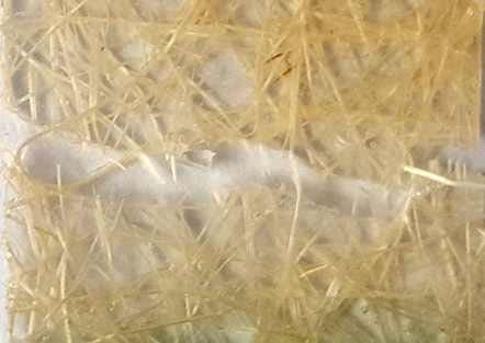 Enquanto que o aspecto da fratura do compósito reforçado por manta de fios de juta de 50 mm, indicado na Figura 9, demonstra presença em excesso de fibras expostas, indicadas pelas setas,