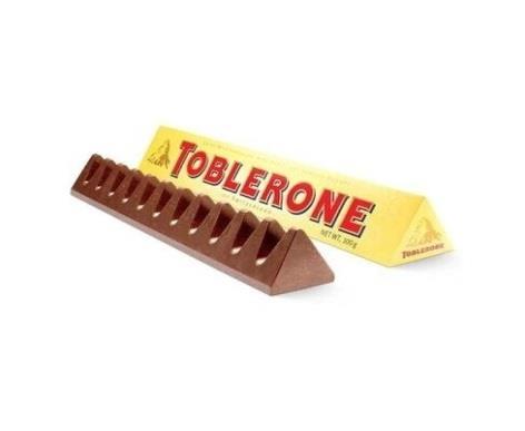 05- O Toblerone é um chocolate suíço conhecido mundialmente. Sua embalagem, conforme figura a seguir representa um(a): a) Pirâmide. b) Prisma. c) Cilindro. d) Cone.
