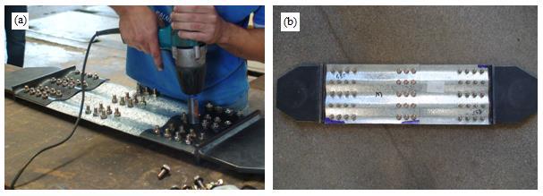 Estes dispositivos possuíam geometria concordante à dos corpos de prova de um lado, ligados por solda de filete a uma chapa plana do outro, para possibilitar o encaixe com as garras da máquina de