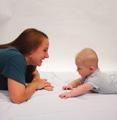 Ajude seu bebê a impulsionar seu corpo, usando os cotovelos, para levantar a cabeça para olhar para você. Certifique-se de segurar seu bebê abaixo do peito dele.