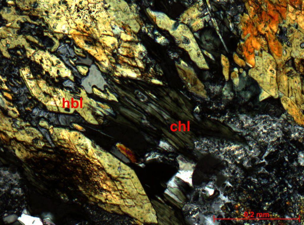 tr-act Figura 9 - Fotomicrografia de xisto verde mostrando tremolita-actinolita (tr-act) orientada