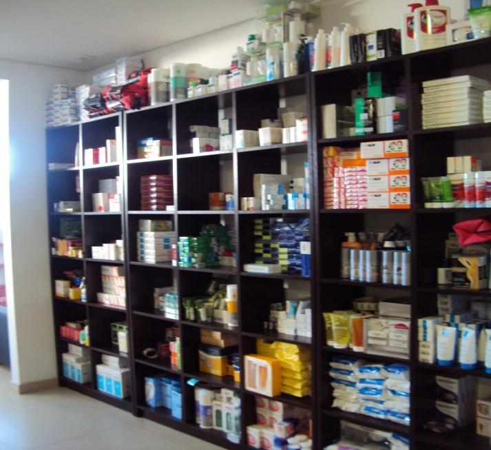 estão arrumados os excedentes dos vários produtos da farmácia (Figura 22 e Figura 23). O local é composto por vários armários e uma banca.