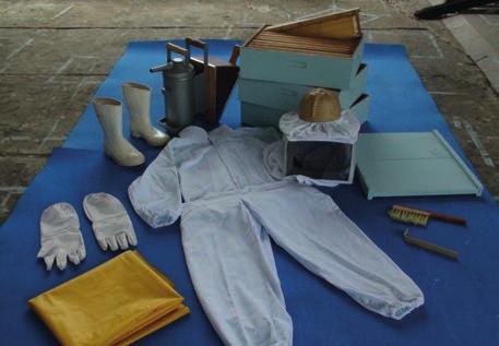 1 - Reúna o material Lona limpa, indumentária (EPIs), fumigador, melgueiras contendo quadros com favos construídos ou