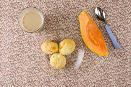 laranja natural, pão francês com manteiga e mamão Café com leite, pão de queijo e mamão