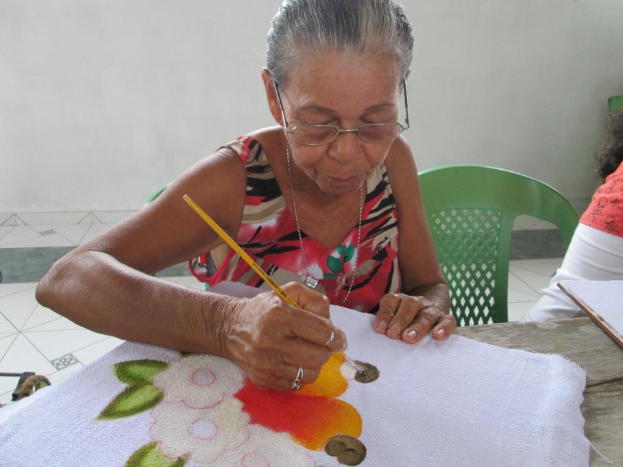 Figura 17 Dona Rita, uma das matriarcas da comunidade participando do curso de pintura em tecido.