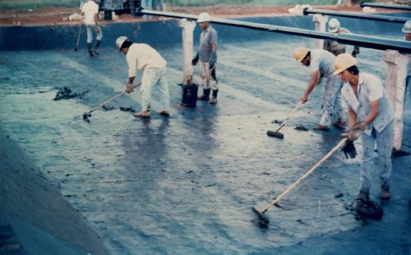 FOTO 3 (Mai/88) Aspecto do sistema de impermeabilização executado com geotêxtil Bidim impregnado com asfalto após a segunda aplicação de emulsão asfáltica diluída em água.
