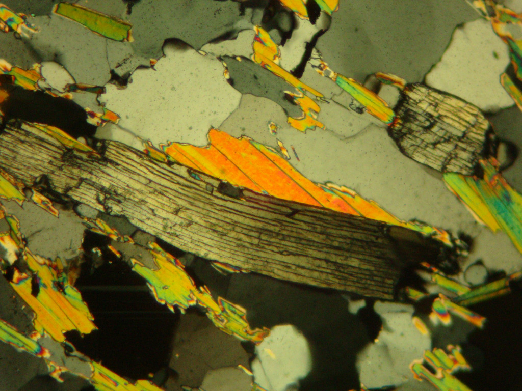 Extinção Ondulante Direções ópticas x Cristalográficas Desenvolvida quando um mineral fica sujeito a esforços compressivos