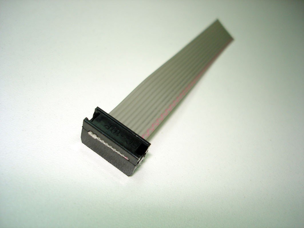 O cabo deverá ser encaixado no espaço livre entre o segmento de plástico e as lâminas de metal. Verifique se ele está alinhado com o conector.