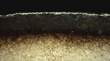 Observa-se que a camada composta apresenta-se com 0,015mm de profundidade e um elevado grau de porosidade, característico do processo de nitretação em banho de sal.
