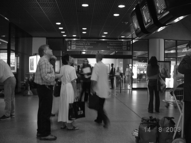Como o monitor fica alto, a aproximação provoca uma extensão do pescoço. Figura 52 Passageiros olhando nos monitores no saguão de check-in (esquerda) e no saguão de embarque (direita).