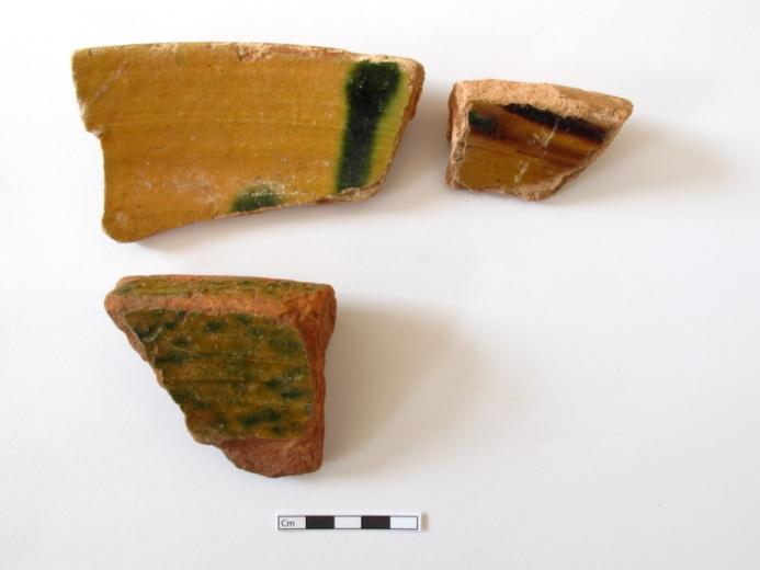 768 JFM/06-22-3533 PÚCARO Fragmento de base de assentamento anelar de um púcaro de cerâmica esmaltada verde lisa, com duas caneluras na