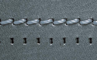 do couro com força. Os furos de costura são longos e bem visíveis na costura.