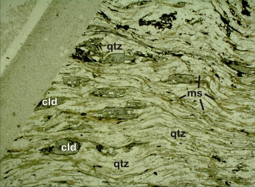 Figura 4-6: Micro-porfiroblastos de cloritóide em matriz de muscovita e quartzo. Notar o estiramento do cloritóide veja observação acima.