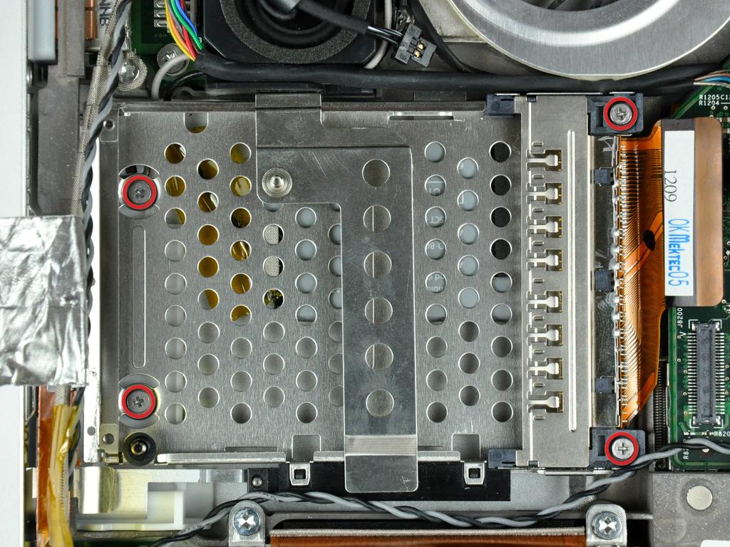fora da borda do compartimento de placa PC perto da lateral da caixa inferior.