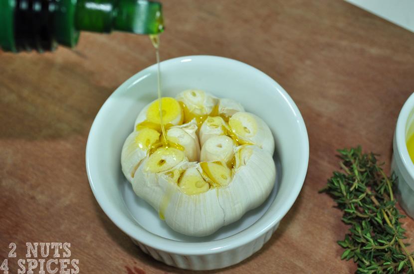 Depois coloque a cabeça de alho já cortada em um potinho que vá ao forno. Regue os dentes de alho expostos com azeite de oliva.