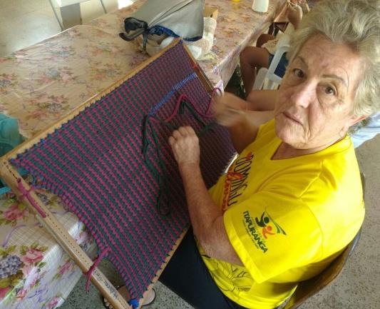 Figura 3: Maria Helena da Rocha produzindo seu tapete de tiras na grade. Foto: Andressa Rodrigues Santos. Jun/2016.