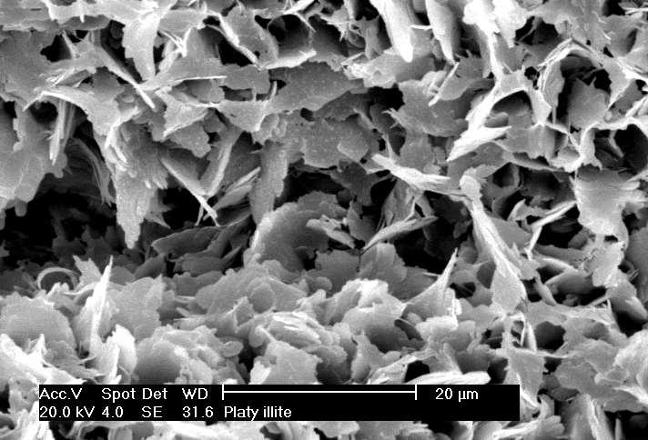 Microfotografia de ilita proveniente da decomposição de mica muscovita: fomas lamelares menos regulares do que nas caulinitas pouco expansivas e, por isso, sua resistência modifica-se