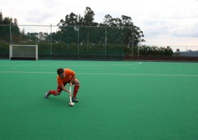 Erro frequente: O stick do jogador entra em contacto com a metade superior da bola. Correção: O peso do corpo do jogador encontra-se sob a perna esquerda (traseira).