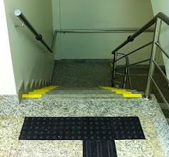 10; b) sinalização em Braille, informando sobre os pavimentos no início e no final das escadas fixas e rampas, instalada na geratriz superior do prolongamento horizontal do corrimão. Figura 4.