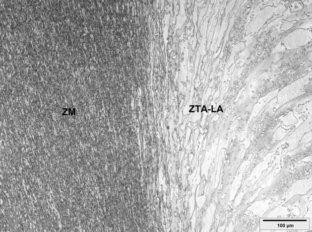 Figura 4 - Micrografia obtida por microscopia óptica na região de transição entre a zona misturada (ZM) (à esquerda) e a zona termicamente afetada, no