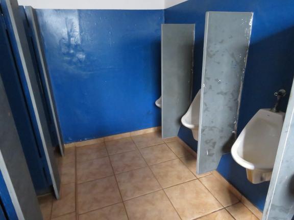 O sanitário masculino está em boas condições de conservação, possui piso de cerâmica e paredes pintadas.