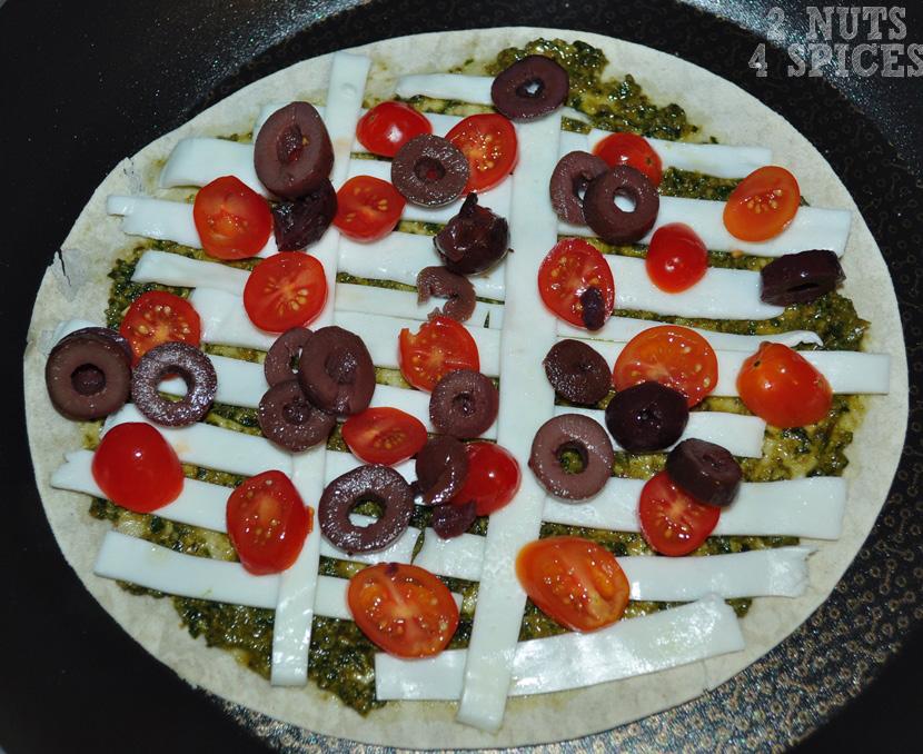 Coloque os tomates e azeitonas sobre a pizza e ligue o fogo em temperatura média ou baixa e deixe até que o queijo derreta.