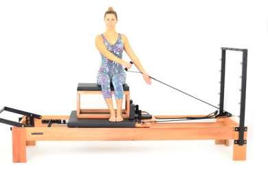 103 221. Rowing Vertical: Unilateral Fortalecer os músculos deltoide, trapézio e abdômen. 1. Sentado na caixa do Reformer, posicionada paralelamente ao apoio de ombros, de lado para a barra de pés.