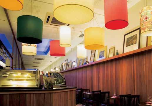 Na área do café/bar, luminárias decoram e identificam visualmente o ambiente. Café/bar Luminárias pendentes artesanais, feitas sob medida, são um ponto forte da estética estabelecida pelo projeto.