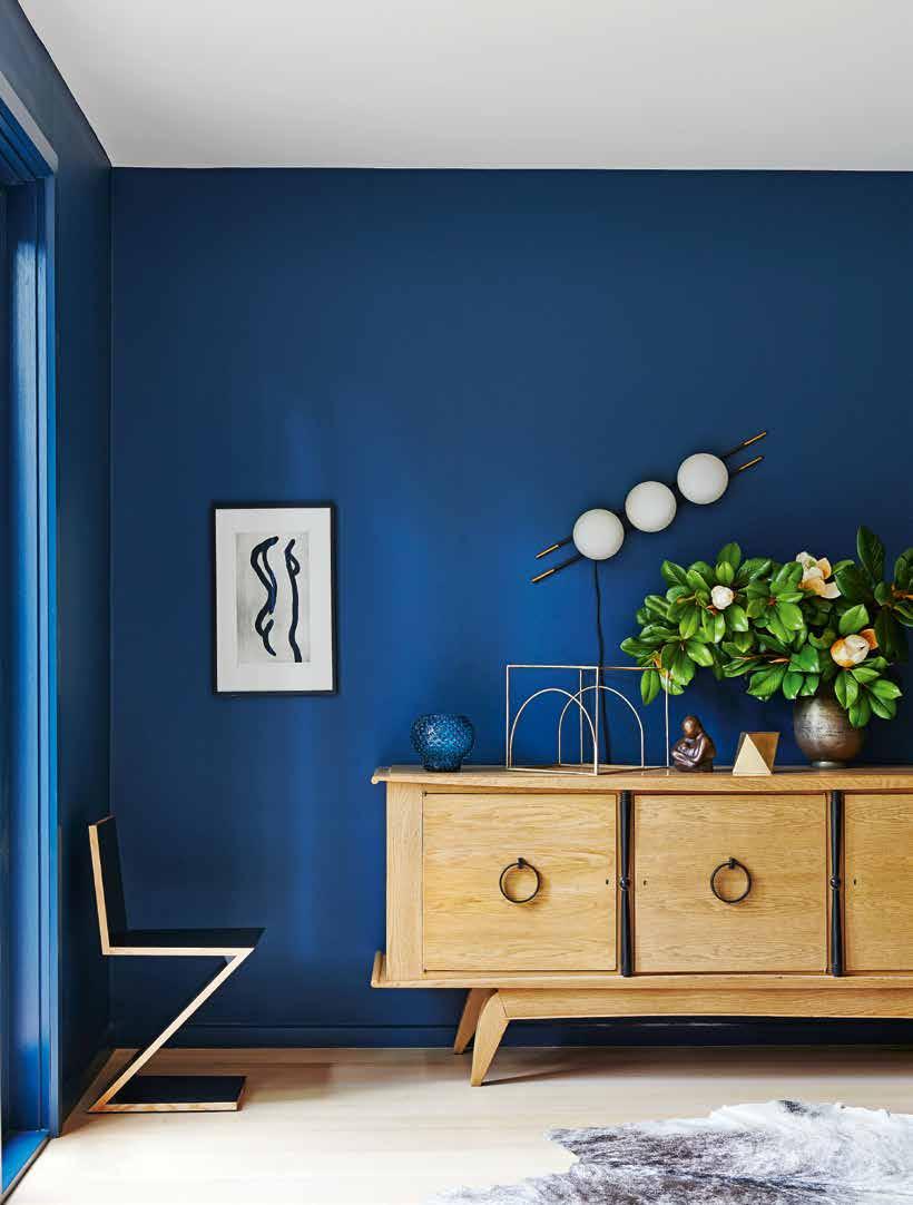 EQUILÍBRIO A escolha pela madeira clara no piso e no mobiliário, como o aparador da década de 1950, contrasta com o azul das paredes.