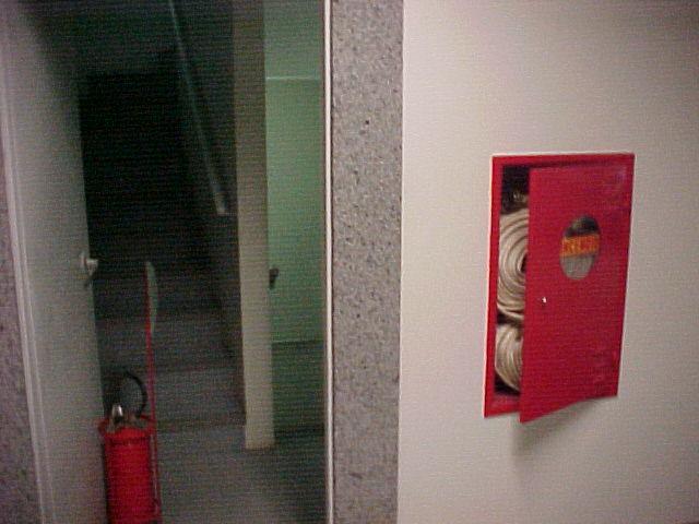 Extintor segurando porta de escada de incêndio Fuga de ar frio devido abertura de portas de escada de incêndio Alberto