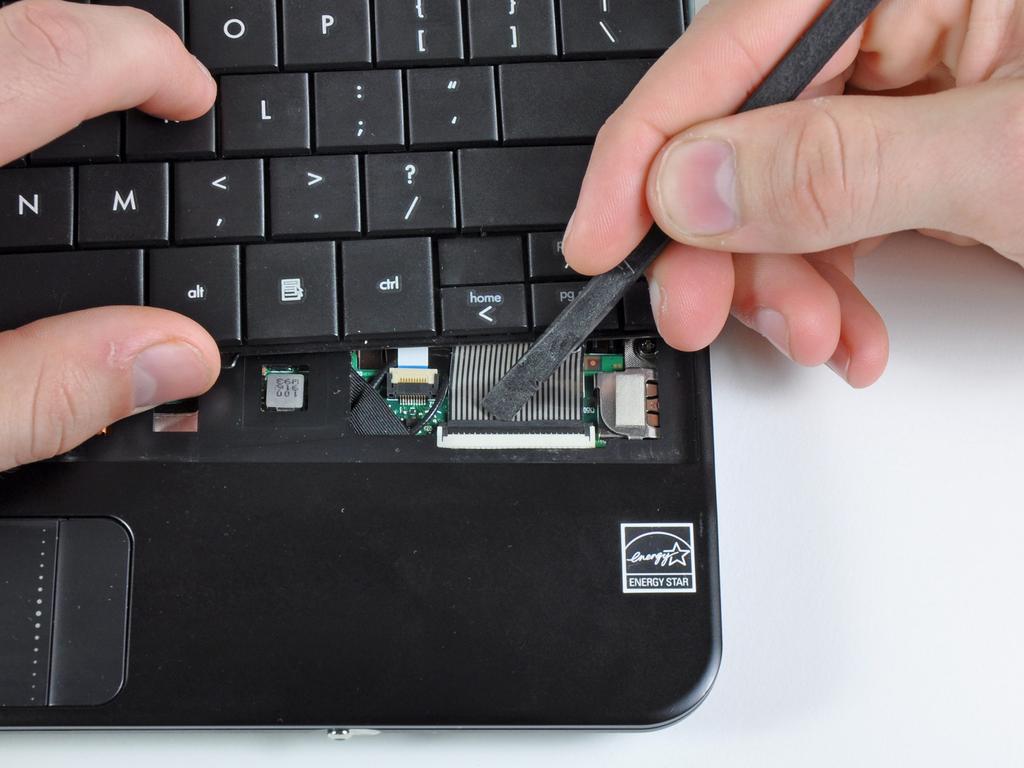 Use a unha ou a extremidade plana de uma SPUDGER para virar para cima a aba de retenção no soquete do teclado cabo
